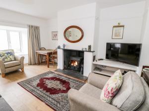 a living room with a fireplace and a tv at Groes Newydd in Llandecwyn