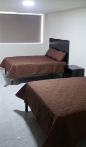 two beds in a room with two beds sidx sidx sidx at Hotel Estadía in León