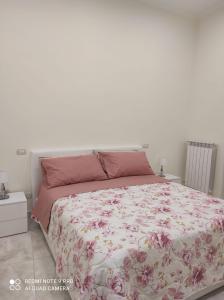 una camera da letto con un letto con copriletto floreale di Casa Fofo' a Napoli