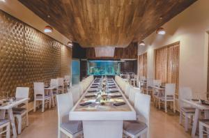 a dining room with a long table and white chairs at Desire Riviera Maya Resort All Inclusive - Couples Only in Puerto Morelos +37 photos