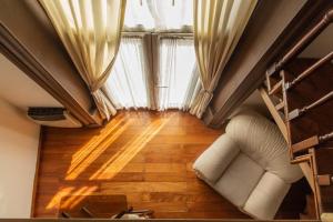 sala de estar con sofá y ventana grande en Loft Argentino Apart Buenos Aires en Buenos Aires