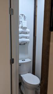 ein Badezimmer mit einem WC und einem Haufen Handtücher in der Unterkunft Clingan's Junction Cottage #4 in Squaw Valley