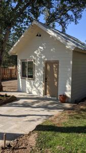 a small white building with a door in a yard at Clingan's Junction Cottage #4 in Squaw Valley