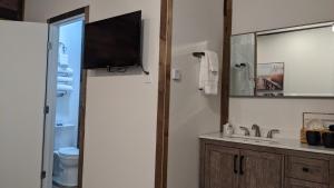 a bathroom with a sink and a tv on the wall at Clingan's Junction Cottage #4 in Squaw Valley