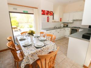 a kitchen and dining room with a table and chairs at Hill Top Farm Cottage in Minwear