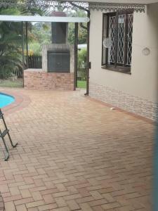 a patio with a fireplace next to a house at The calm corner in Pinetown