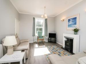 a living room with a couch and a fireplace at The Knowe Lower in Taynuilt