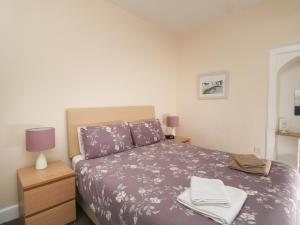 a bedroom with a purple bed with two towels on it at The Knowe Lower in Taynuilt