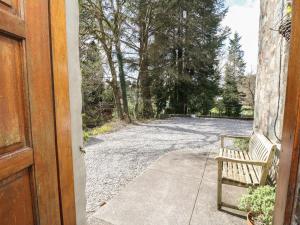 an open door to a driveway with a bench at The Knowe Lower in Taynuilt