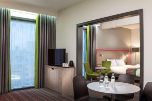 a living room with a large mirror and a large window at Park Inn by Radisson Manchester City Centre in Manchester