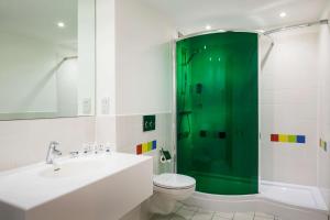 a bathroom with a toilet and a green shower at Park Inn by Radisson Manchester City Centre in Manchester