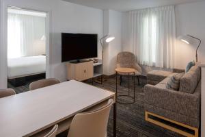 a hotel room with a bed and a living room at Sonesta Simply Suites Falls Church in Falls Church