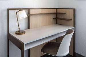 a desk with a lamp and a white chair at Sonesta Simply Suites Falls Church in Falls Church +21 photos