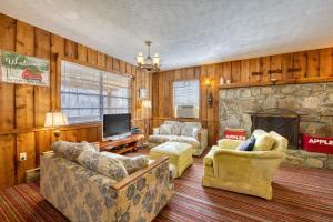 uma sala de estar com sofás e uma lareira de pedra em Tara's Dream Mountain Cabin em Canton