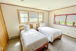 two beds in a room with two windows at Summertime in Bar Harbor
