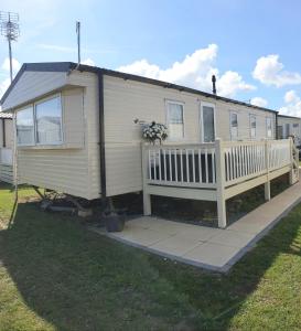 Kent的住宿－Griffiths, Seaview Caravan Park, Whitstable，移动房屋设有门廊和围栏