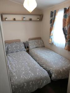 two beds in a small room with a window at Griffiths, Seaview Caravan Park, Whitstable in Kent