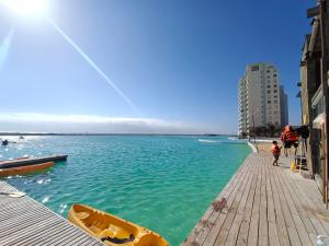 a boat on a dock next to a body of water at Departamentos Laguna del Mar in La Serena