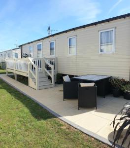a patio with a table and a building at Griffiths, Seaview Caravan Park, Whitstable in Kent