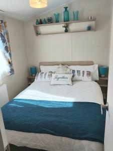 a bedroom with a large bed with pillows on it at Griffiths, Seaview Caravan Park, Whitstable in Kent