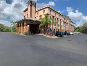 un grand bâtiment avec une tour d'horloge dans un parking dans l'établissement Econo Lodge, à Wesley Chapel