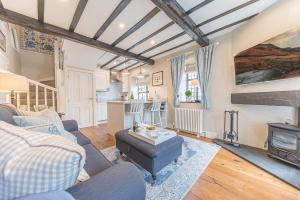 ein Wohnzimmer mit einem Sofa und einem Kamin in der Unterkunft Alice's Cottage in Ambleside