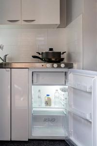 a kitchen with an open refrigerator with a pot on top at Luxury one bedroom guesthouse M6, Junction 10 Walsall in Willenhall