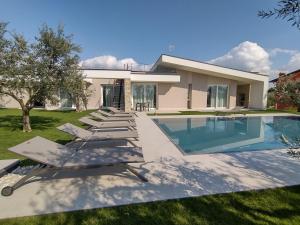 a house with a swimming pool and lounge chairs at La Rondinella Apartments in Bardolino