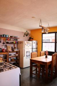 uma cozinha com uma mesa e um frigorífico branco em Casa Huipil em San Cristóbal de Las Casas