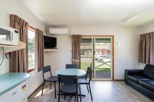 a living room with a table and chairs and a couch at Gundagai Cabins & Tourist Park in Gundagai