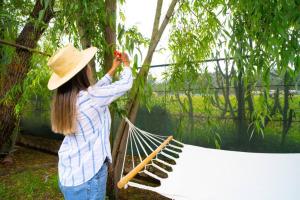 a woman in a hat taking a picture of a hammock at Bungalow Cajamarca, con Wifi y Cochera in Cajamarca