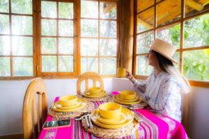 a woman sitting at a table with a cup of coffee at Bungalow Cajamarca, con Wifi y Cochera in Cajamarca +7 photos