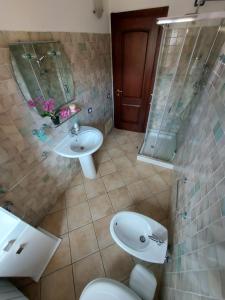 a bathroom with a sink and a toilet and a shower at Affittacamere Center Room in Tortolì