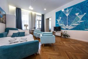 una camera da letto con divano blu e un soggiorno di Apartrezidence Opletalova a Praga