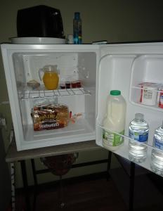 an open refrigerator with a bottle of milk and eggs at 1 ivy cottages the street norton subcourse NR146RS in Norwich
