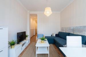un salon avec un canapé bleu et une télévision dans l'établissement CHARMING 2 ROOMS APARTMENT, 3 beds, 8 min walk to Las Canteras Beach, à Las Palmas de Gran Canaria