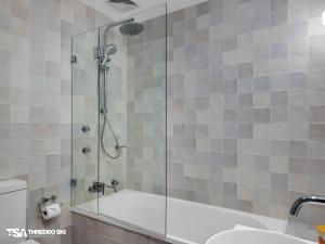 a bathroom with a shower with a tub and a sink at Stepping Stone in Thredbo +30 photos