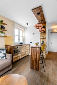 Una cocina y una sala de estar con un sofá y una mesa. en *DISNEYLAND-SERRIS* Studio Cosy, en Serris