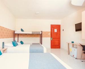Habitación con 2 camas y puerta roja en Hotel Rivera Del Mar en Barranquilla