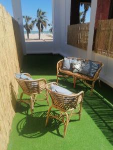 3 sillas de mimbre y un sofá en el patio en Bet&CoBeach Apartments, en Valencia
