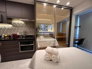 una camera con due letti e una cucina con due letti di Studios Sampa - Brooklin a San Paolo