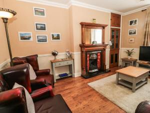 a living room with a couch and a fireplace at Coquet Cottage in Amble