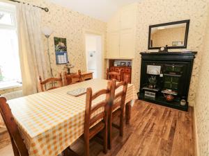 a dining room with a table and a fireplace at Coquet Cottage in Amble