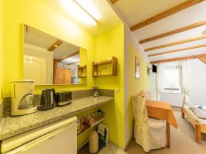 a kitchen with yellow walls and a counter top at Gorgeous Apartment in Grundshagen with parking in Klütz