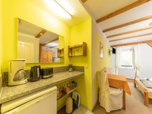 クリュツにあるGorgeous Apartment in Grundshagen with parkingの黄色の壁のキッチン(カウンタートップ付)