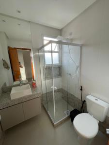 a bathroom with a shower and a toilet and a sink at Apartamento Praia do Morro in Guarapari