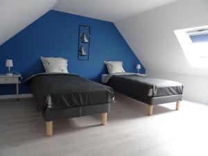 2 letti in una camera con parete blu di Cottage, Douarnenez a Douarnenez