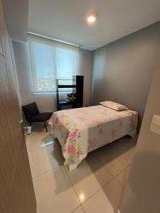 a bedroom with a bed and a chair and a window at Bambu-Rivera Club Residences in San José