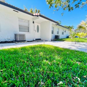 uma casa com um relvado verde em frente em Coco Bay Vacation Condos em Fort Lauderdale