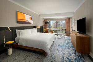 um quarto de hotel com uma cama e uma televisão em voco Orchard Singapore, an IHG Hotel em Singapura